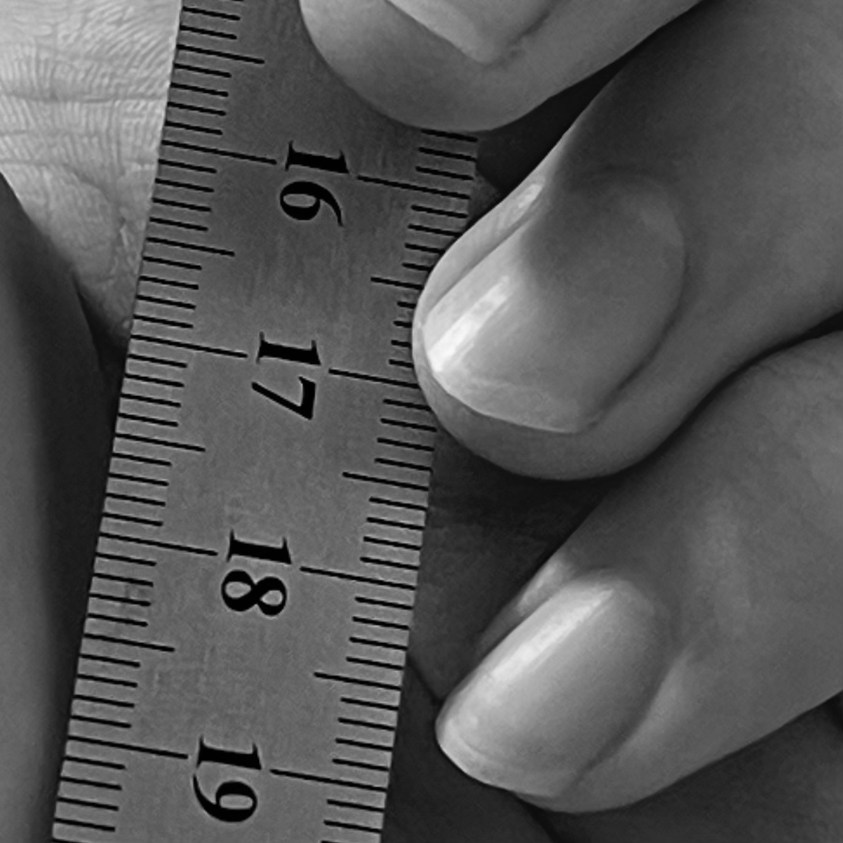 A hand holding a ruler